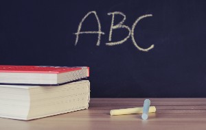 Bücher, Kreide und eine Tafel mit der Aufschrift ABC